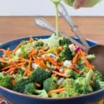 Pouring avocado dressing into broccoli salad
