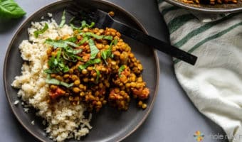 Indian Lentils on plate with Cauliflower Rice with black fork--on gray table with white cloth napkin