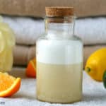 homemade body wash in bottle with towels and citrus fruits