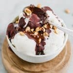 Vanilla ice cream topped with homemade magic shell and nuts in a bowl