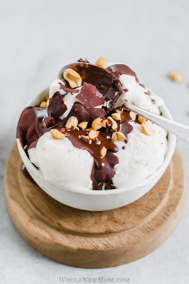 Vanilla ice cream topped with homemade magic shell and nuts in a bowl