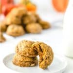 Pumpkin pecan cookies on white plate with jar of milk on white table