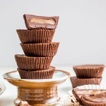 stack of sugar-free peanut butter cups in a wooden pedestal tray.