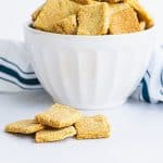 cheez its in a bowl and some pieces on a white tabletop