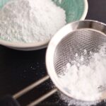 powdered sugar in a sifter and in a bowl.