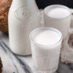 homemade coconut milk in glasses and carafe.