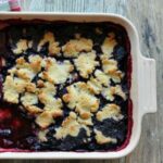 berry cobbler on a white baking dish.