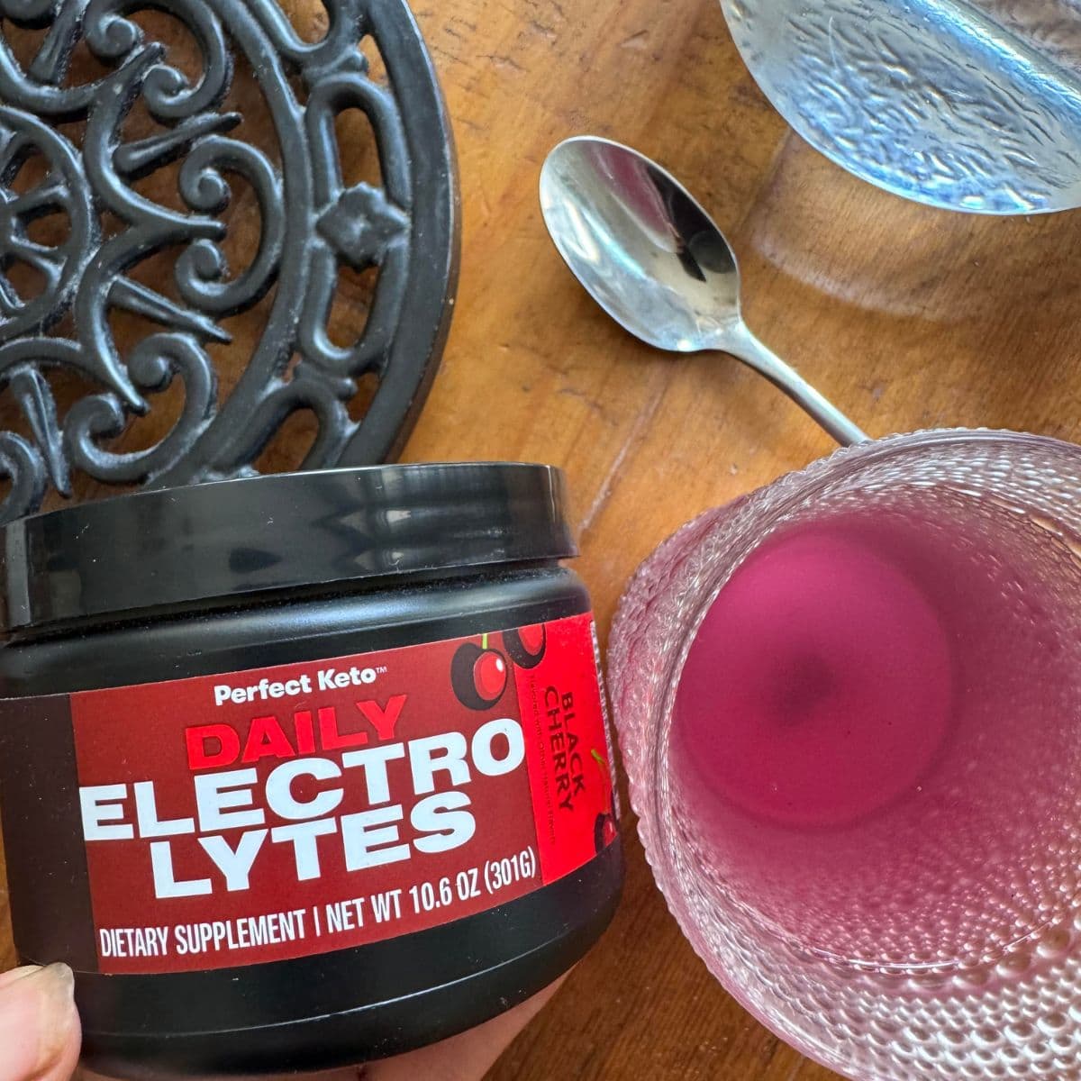 perfect keto electrolytes next to a glass of the electrolytes in a glass with water.