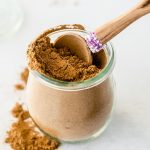 homemade pumpkin pie spice in glass jar with small wooden spoon.