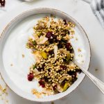 buckwheat granola with yogurt in white bowl.