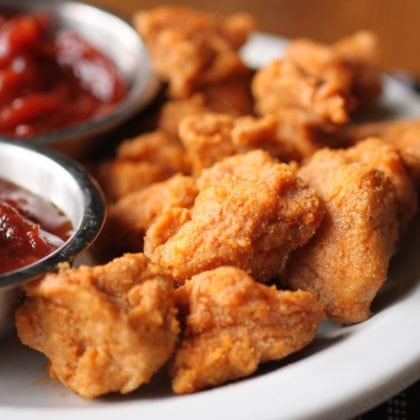 gluten free chicken nuggets on white plate with bbq dipping sauce.
