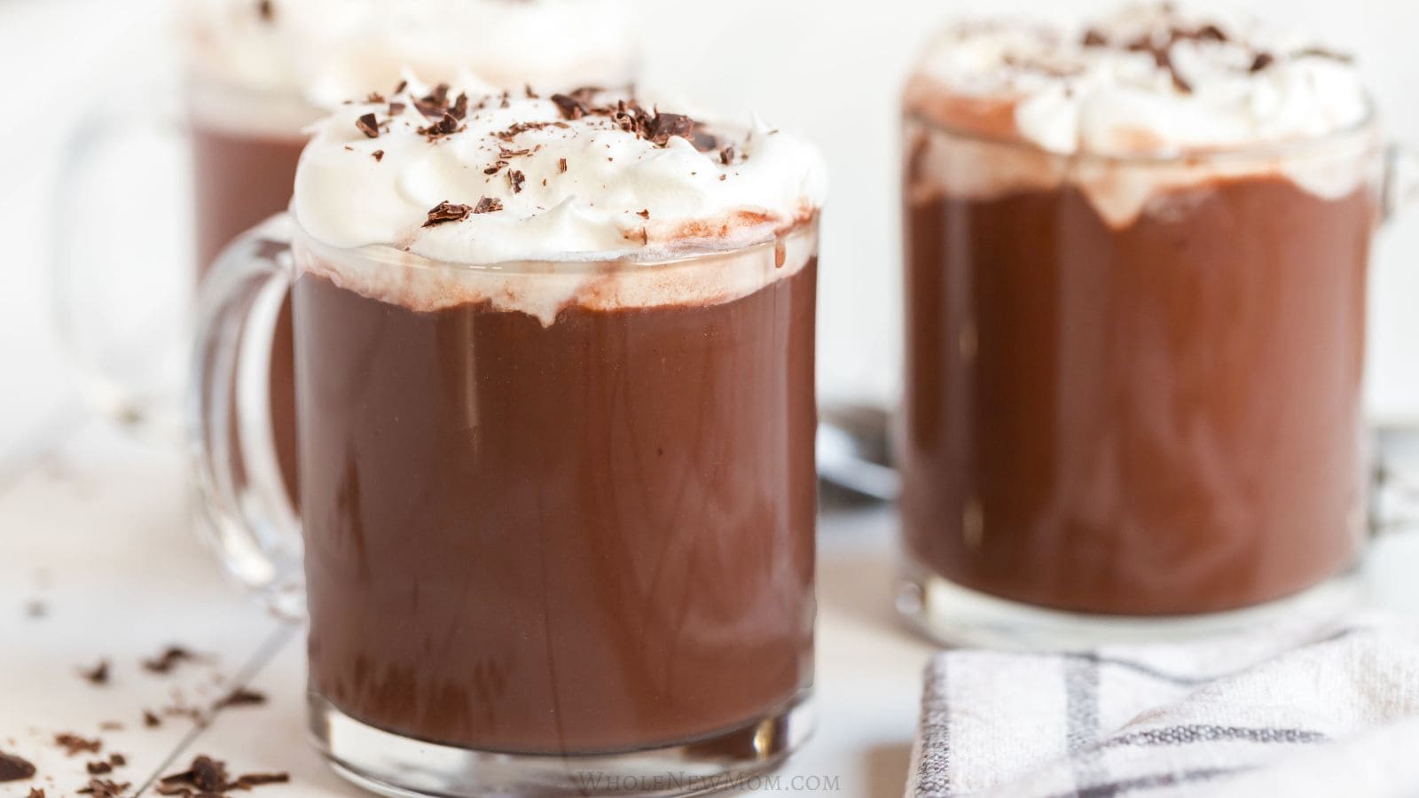 protein hot chocolate in glass mugs with whipped cream.