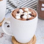 protein hot chocolate with marshmallows and chocolate chips in white mug.