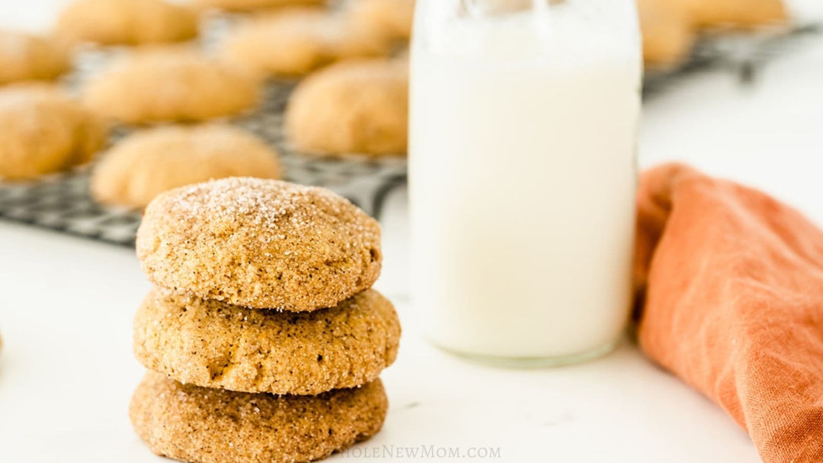 gluten-free pumpkin snickerdoodles in stack with carafe of milk.