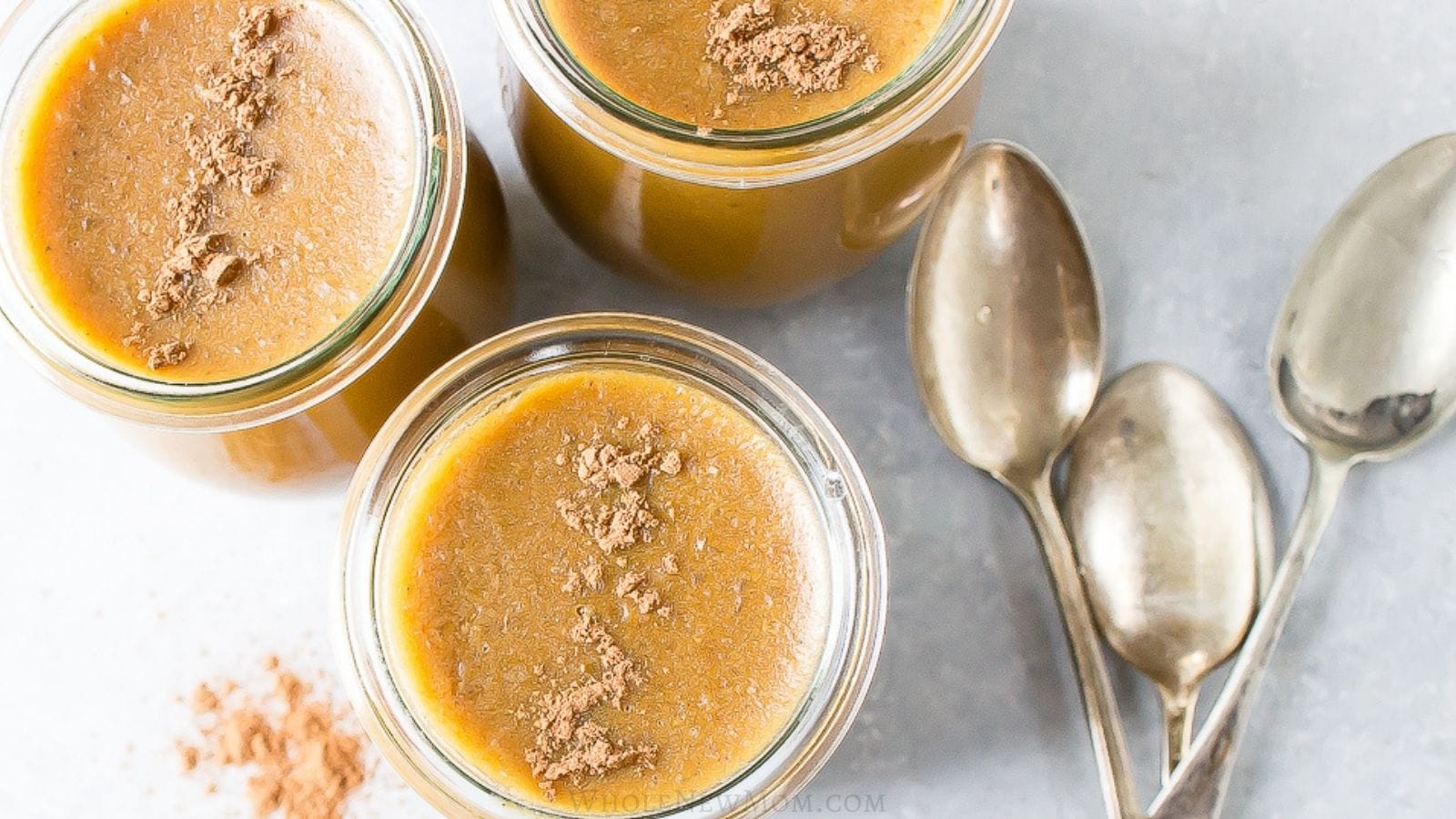 healthy pumpkin custard in glass jars with spoons.