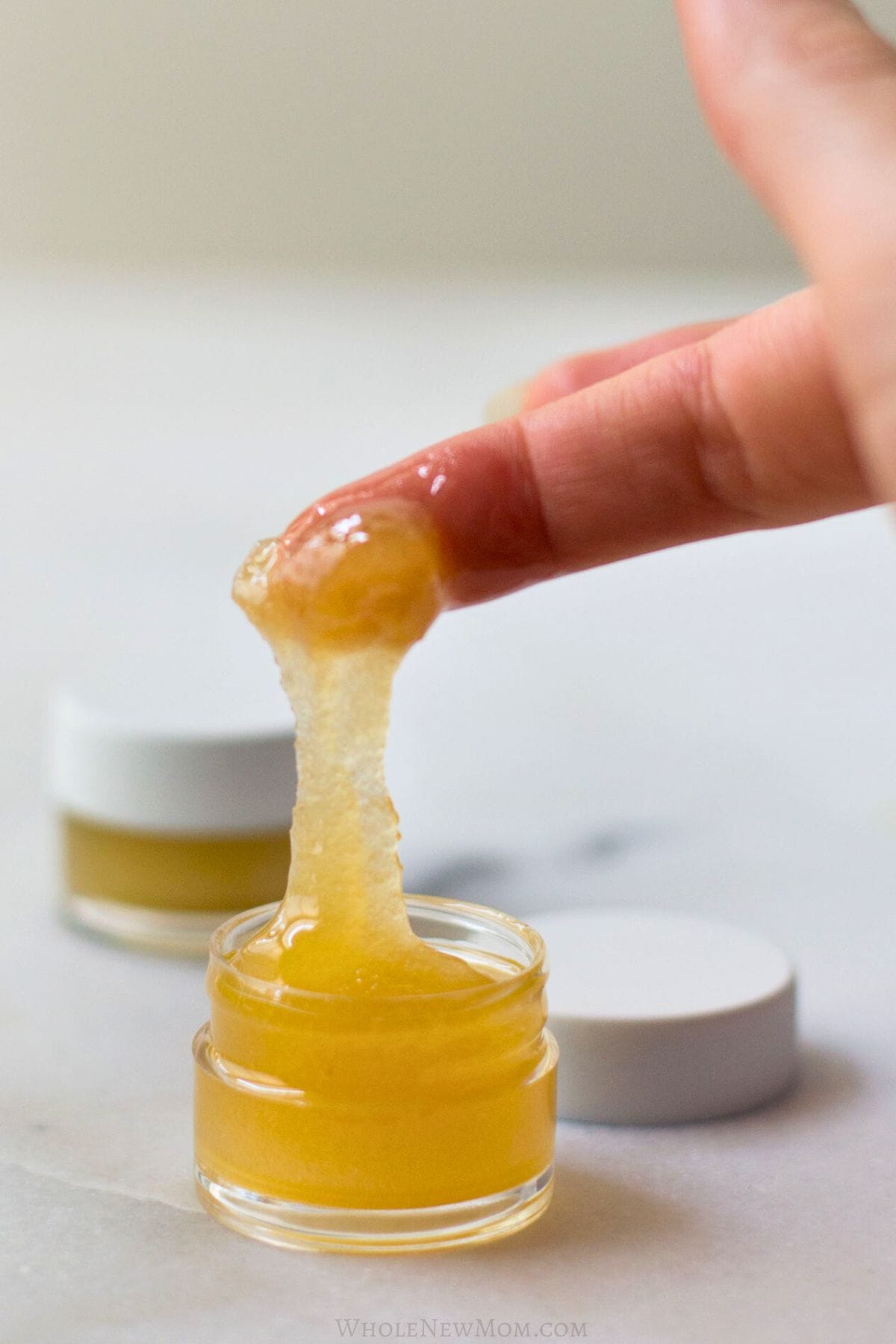 finger scooping diy lip scrub from jar.