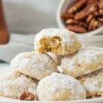 keto snowball cookies with pecans on white plate.