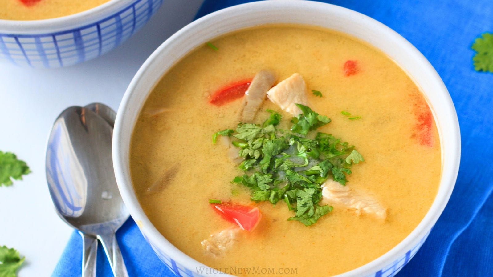 thai coconut chicken soup (tom kha gai) in white and blue bowl.