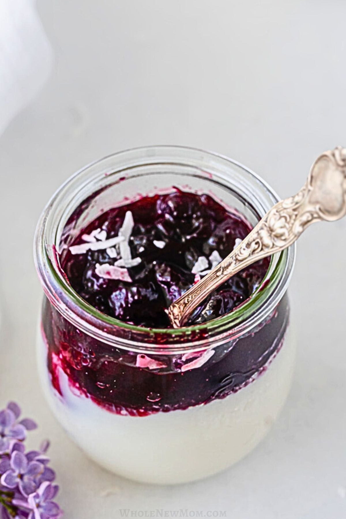 coconut panna cotta in glass dessert jar with spoon.