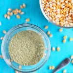 homemade popcorn seasoning in small glass bowl with popcorn kernels.