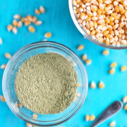 homemade popcorn seasoning in small glass bowl with popcorn kernels.