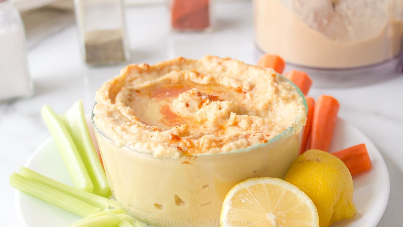 sesame-free hummus in glass bowl with vegetable sticks.