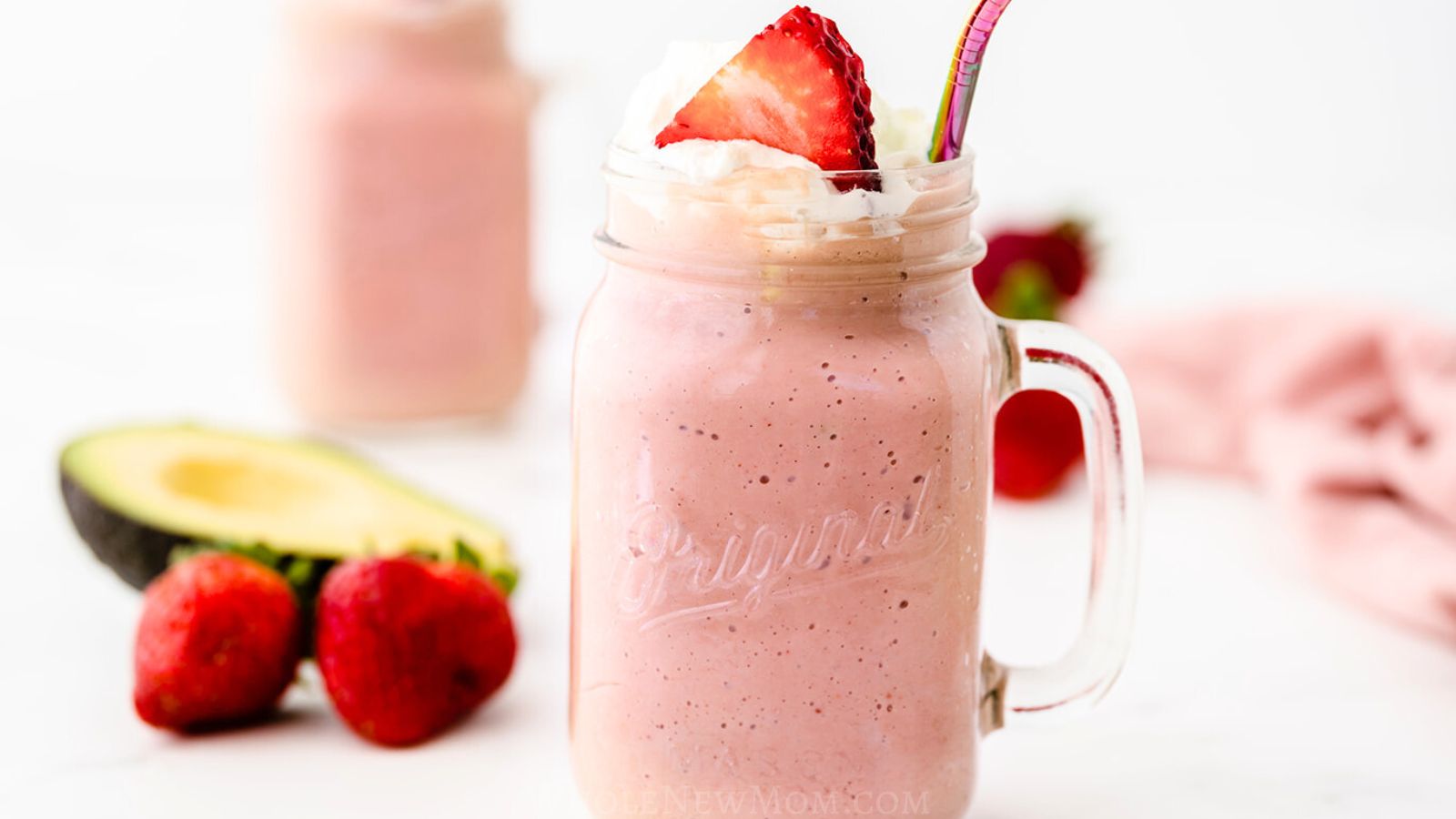 strawberry avocado smoothie in mason jar mug.