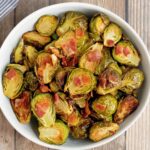 crispy roasted brussels sprouts with bacon in white bowl.