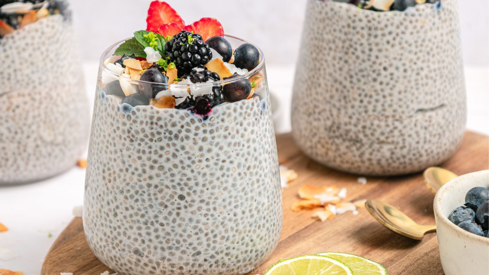 coconut chia pudding in glass jars with berries on top.