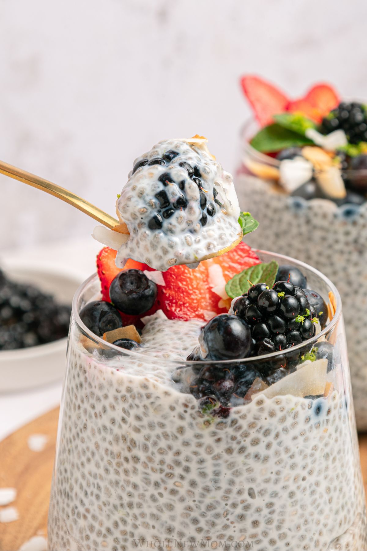 spoonful of coconut chia pudding with berries showing thick creamy texture