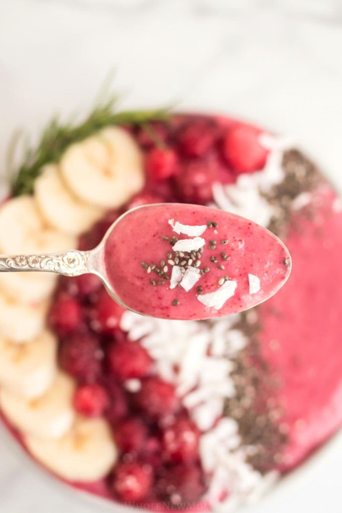 close up of spoon with cranberry smoothie bowl on it.