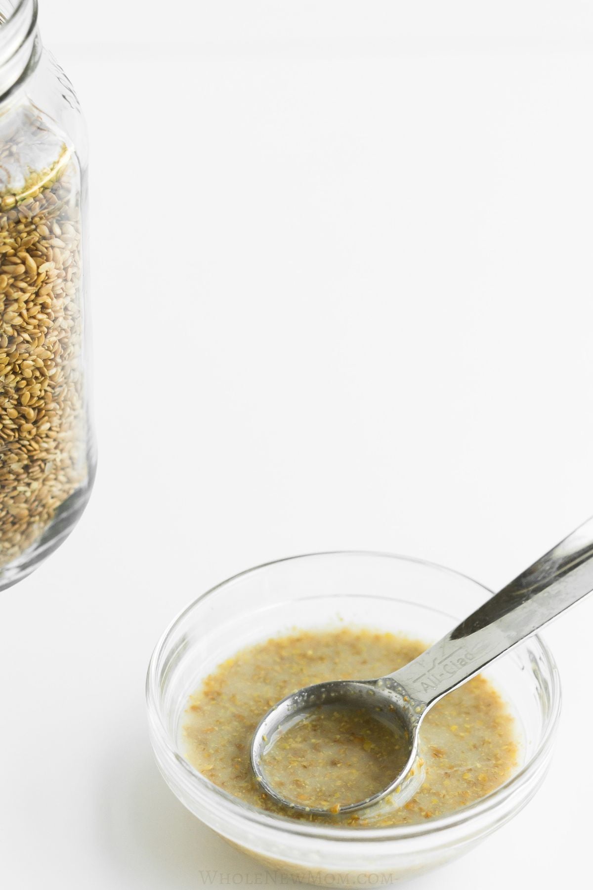 flax egg in small metal bowl with metal measuring spoon.