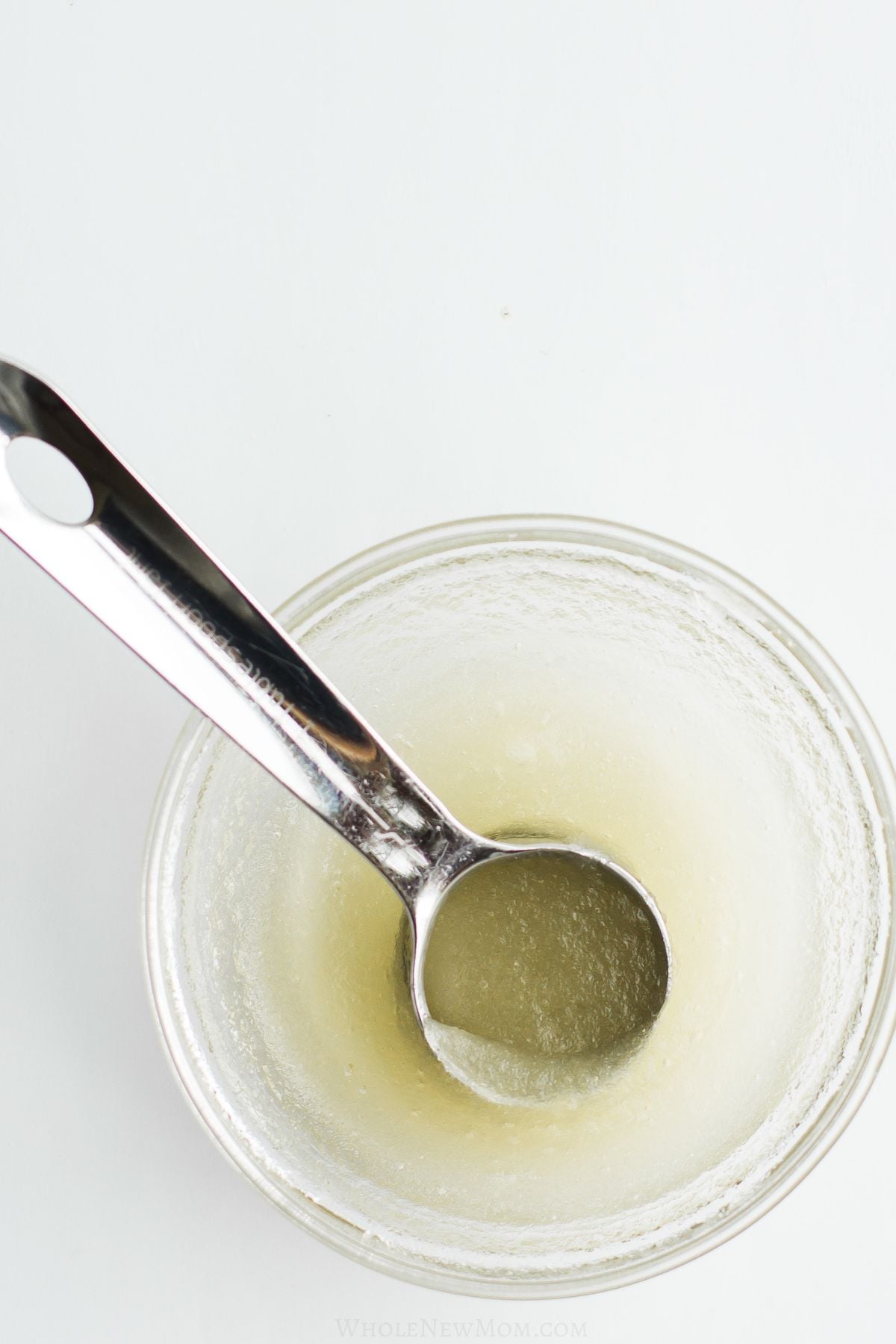 gelatin egg with measuring spoon in small glass bowl.
