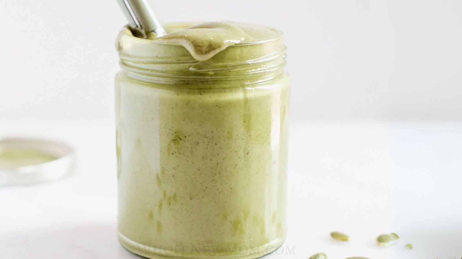 homemade pumpkin seed butter in a jar with a spoon.