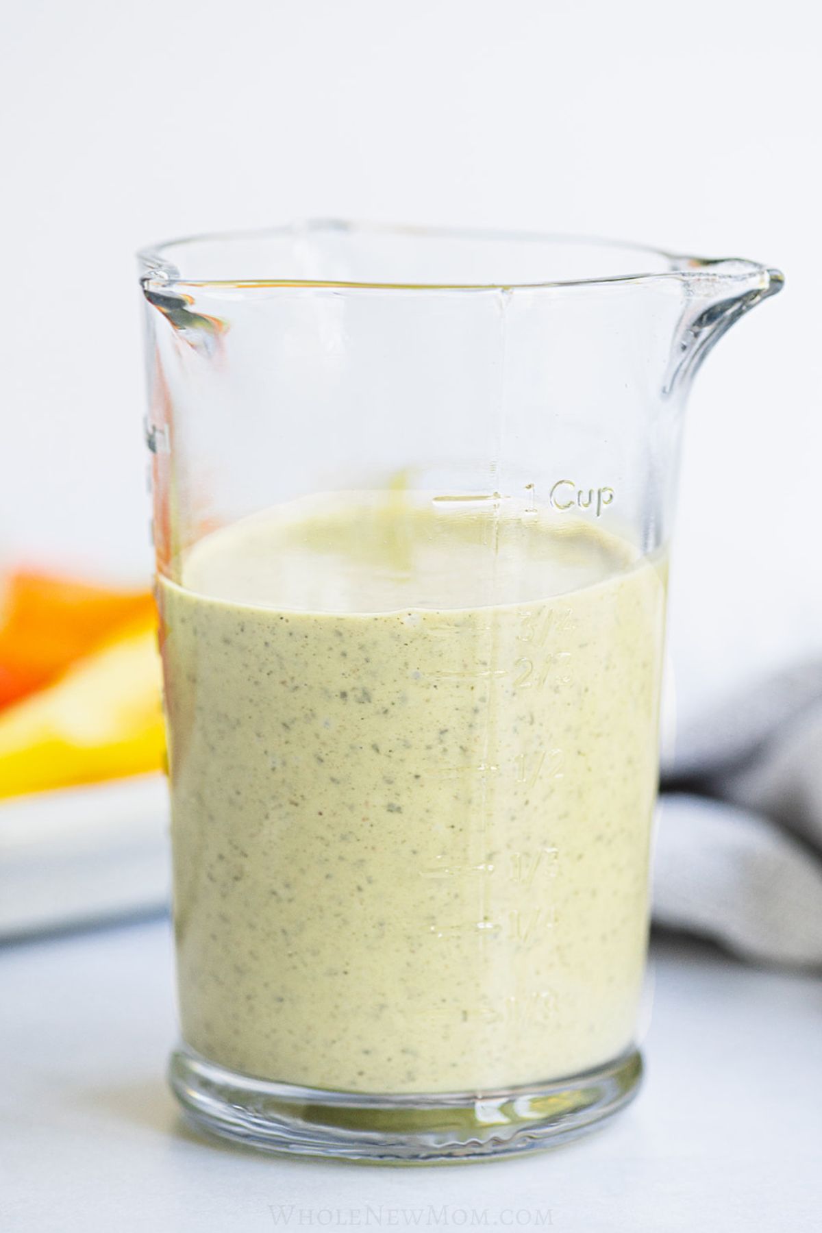 dairy free ranch dressing in glass measuring cup.