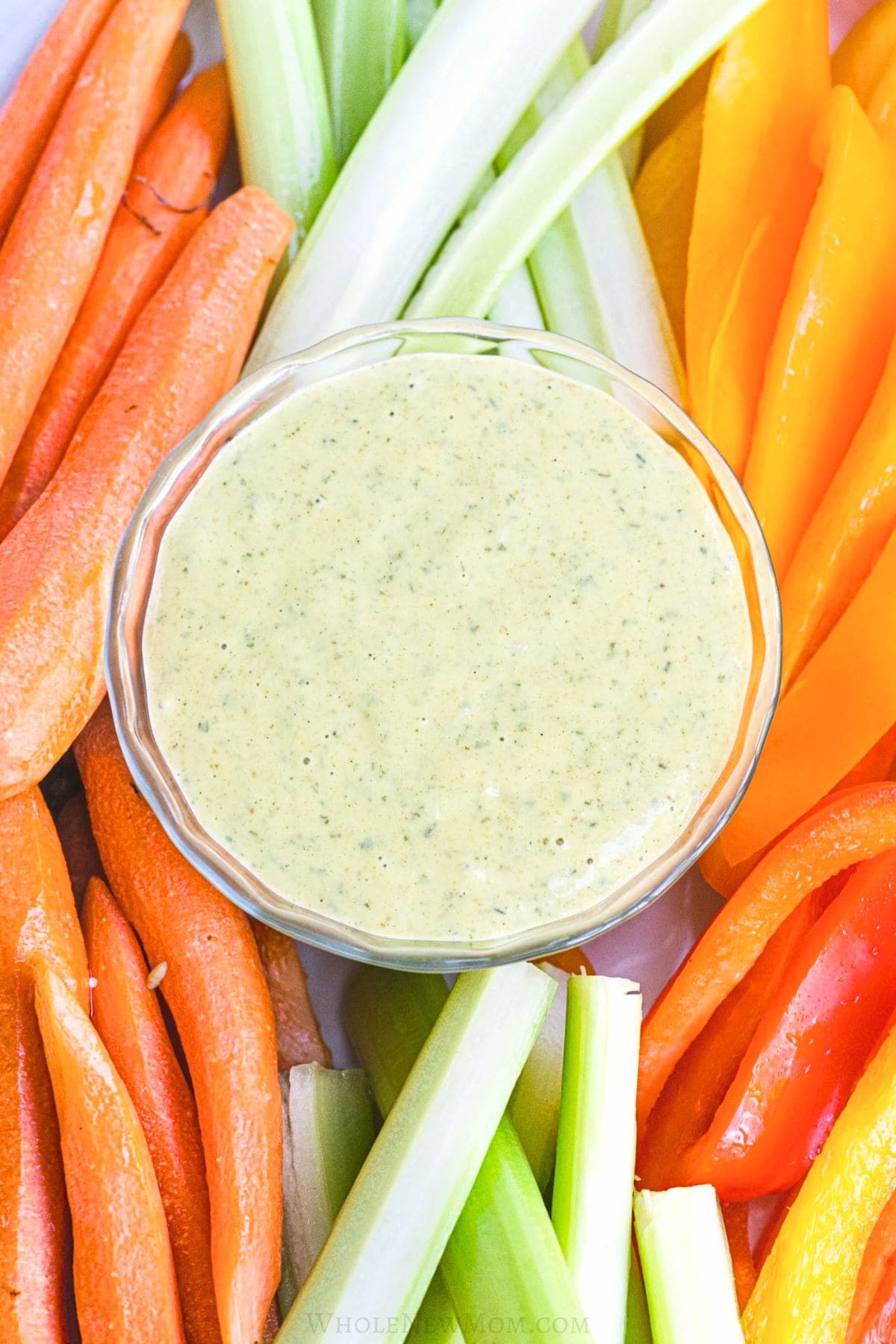 dairy free ranch dressing in glass bowl with vegetable sticks.