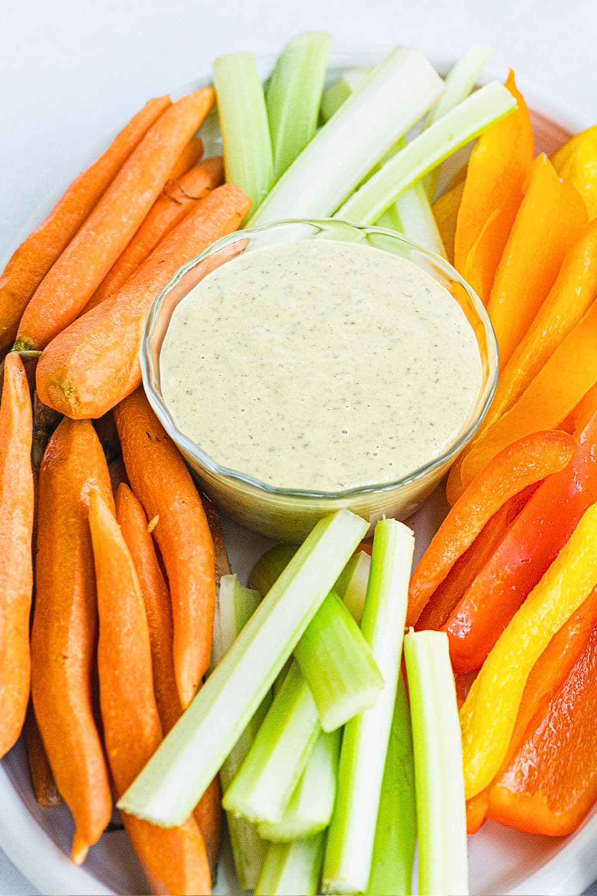 vegan ranch dressing on white platter with vegetables.