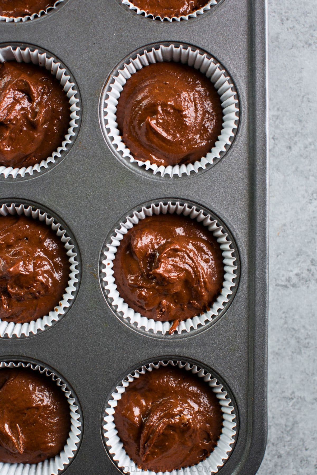 carob muffin batter in muffin tin.