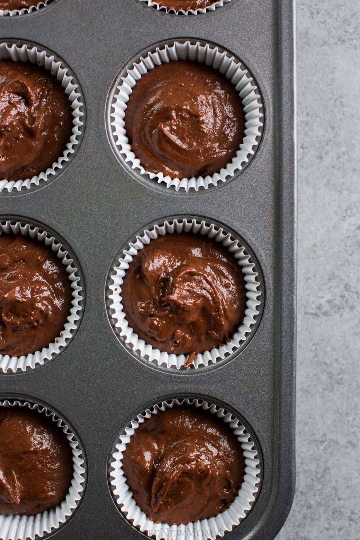 carob muffin batter in muffin tin.