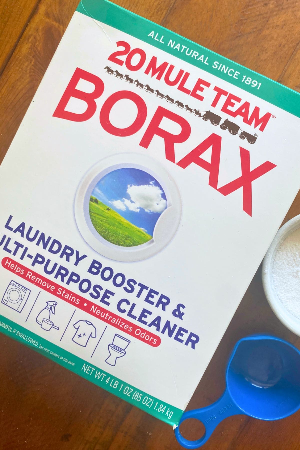 box of mule team borax with borax powder in ramekin and blue measuring cup.