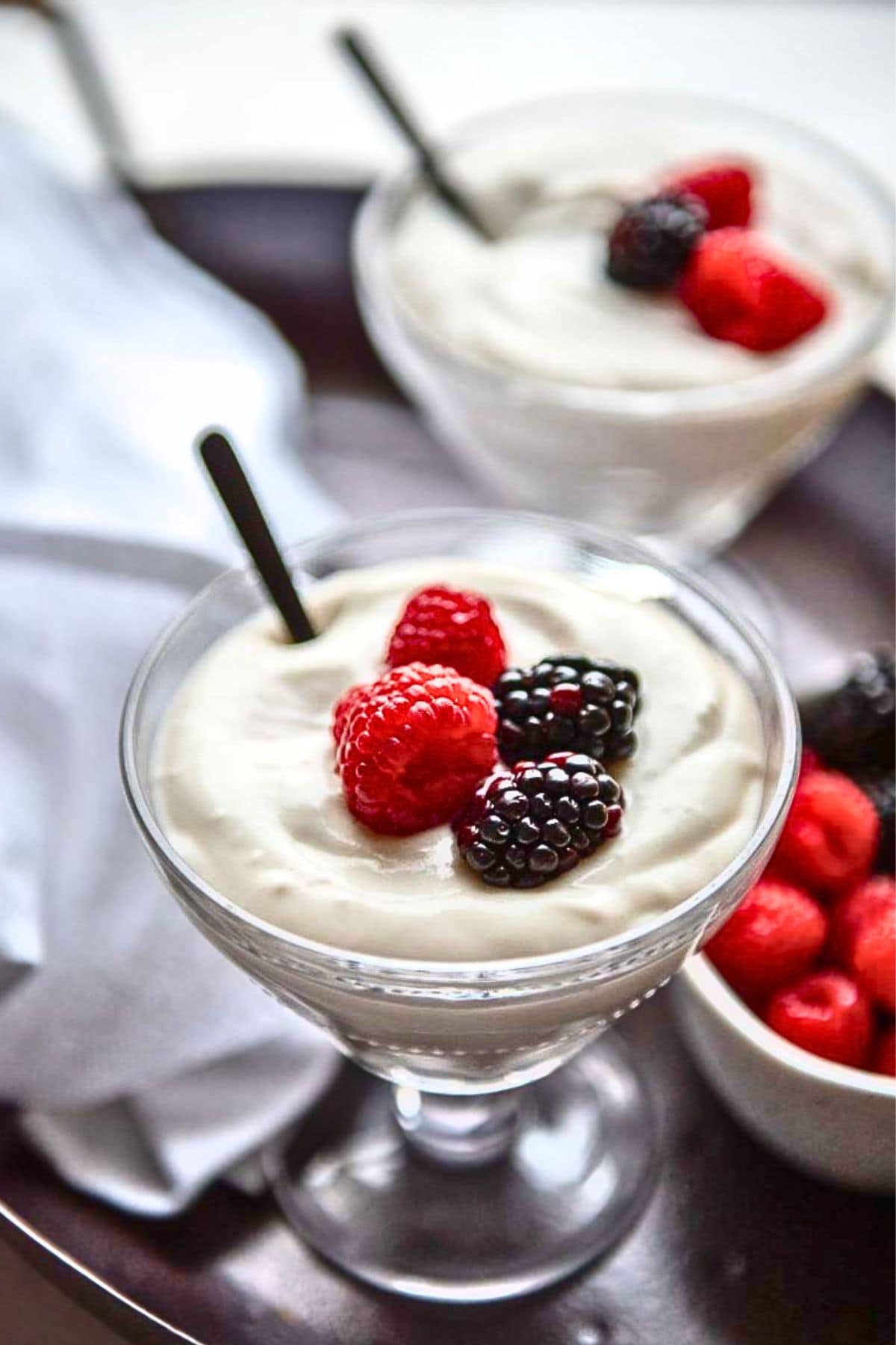 sugar free coconut pudding in glass dessert dish with berries.