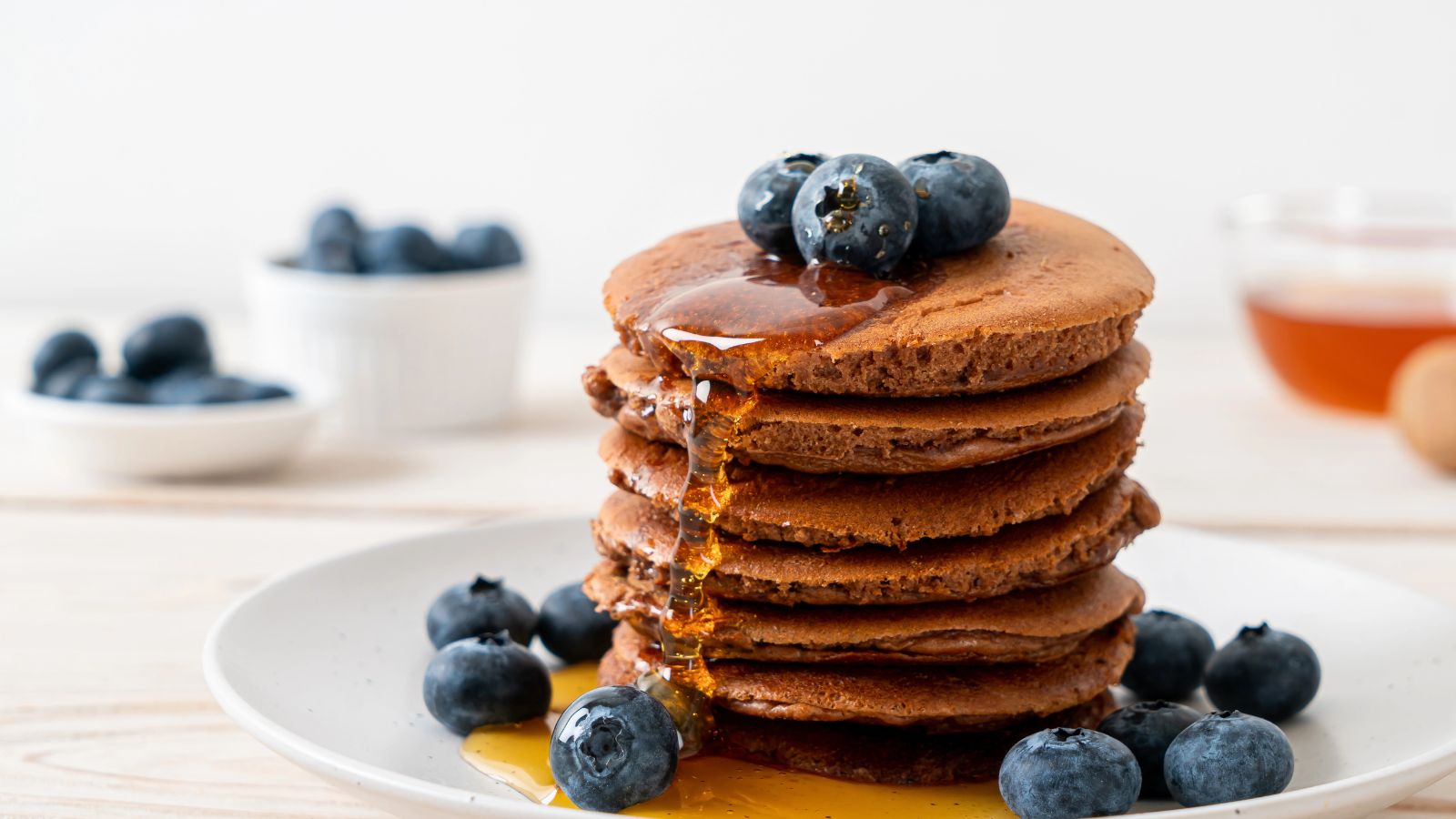 teff pancakes with syrup and blueberries.